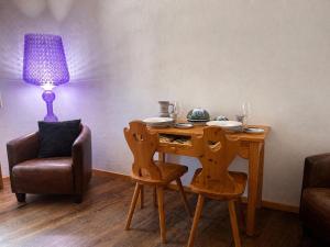 a table with two chairs and a lamp in a room at Bijou Alpina Surlej in Silvaplana +12 photos