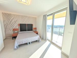 a bedroom with a bed and a large window at Nashira Apartments in Lignano Sabbiadoro