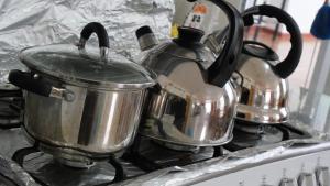 two tea pots and a tea kettle on a stove at Casa jardín Roqui in Puno +41 photos