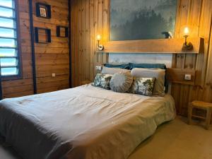 a bedroom with a large bed with wooden walls at River House superbe vue- vue et accès directe sur la rivière et baignade dans les bassins naturels in Saint-Joseph