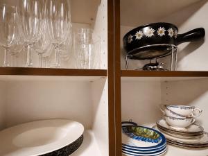 a cupboard with glasses and plates and a bowl at Bijou Alpina Surlej in Silvaplana