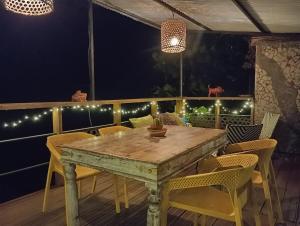 a wooden table and chairs on a deck with lights at River House superbe vue- vue et accès directe sur la rivière et baignade dans les bassins naturels in Saint-Joseph