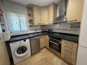a kitchen with a washing machine and a washer at Miramar Playa in La Playa de la Torre de Piles