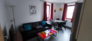 a living room with a black couch and a table at Stadtdomizil in Augsburg