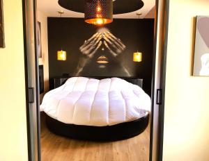 a bed in a room with a persons hands on the wall at Pas Sages in Le Tréport
