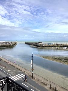 a person riding a motorcycle on a road next to a body of water at Pas Sages in Le Tréport