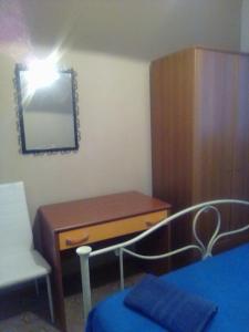ein Schlafzimmer mit einer Kommode und einem Schreibtisch mit Spiegel in der Unterkunft Casa Sofia in Palinuro