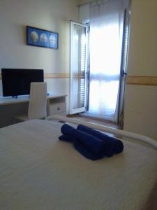 ein Schlafzimmer mit einem Bett, auf dem ein blaues Handtuch liegt in der Unterkunft Casa Sofia in Palinuro