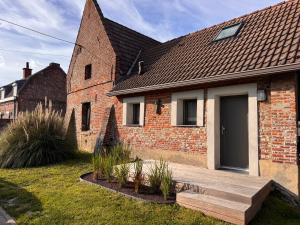 a brick house with a wooden walkway in front of it at L ' Arbre de Guise in Seclin