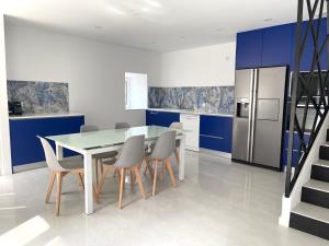 a kitchen with a table and chairs and blue cabinets at Casa das Abelhas in Arcos de Valdevez