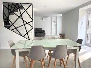 a dining room with a glass table and chairs at Casa das Abelhas in Arcos de Valdevez
