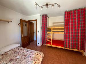 a bedroom with a bed and a red plaid curtain at Casa dello sciatore in Limone Piemonte