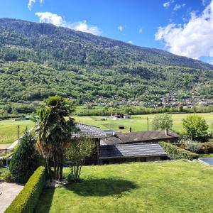 a house in a field with a mountain in the background at BluVilla in Malvaglia