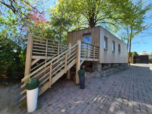 a wooden house with a staircase leading up to it at Tiny House Chimay in Chimay