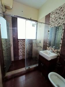 a bathroom with a glass shower and a sink at The Olive County in Thirumurugan Poondi