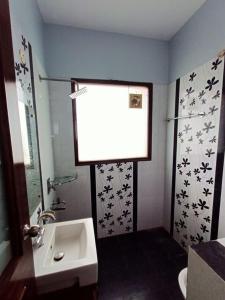 a bathroom with a sink and a shower with a window at The Olive County in Thirumurugan Poondi +2 photos