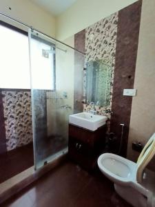a bathroom with a shower and a sink and a toilet at The Olive County in Thirumurugan Poondi