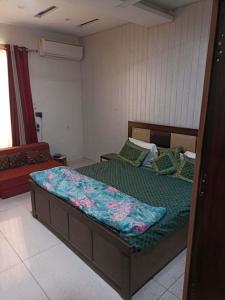 a bedroom with a bed with a green comforter at The Olive County in Thirumurugan Poondi
