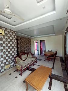 a living room with a table and chairs and a table at The Olive County in Thirumurugan Poondi