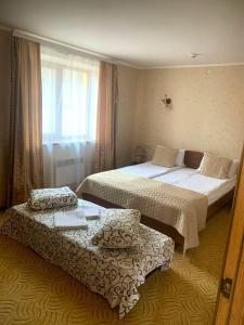 a hotel room with two beds and a chair at Вілія in Lomacineţi +69 photos