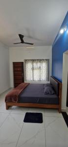 a bedroom with a large bed and a blue wall at Bro Code Marayoor A Premium Family Friendly Retreat with Panoramic Mountain Views in Maraiyūr