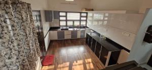 a kitchen with stainless steel appliances and a wooden floor at Bro Code Marayoor A Premium Family Friendly Retreat with Panoramic Mountain Views in Maraiyūr
