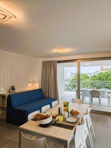 a living room with a blue couch and a table at Nashira Apartments in Lignano Sabbiadoro
