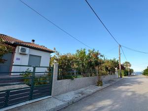 a house with a fence on the side of a street at Villa Violetta in Nea Anchialos