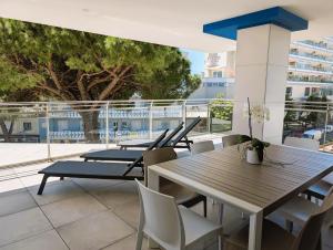 a group of tables and chairs on a balcony at Nashira Apartments in Lignano Sabbiadoro