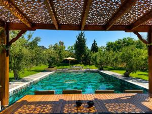 a swimming pool in a backyard with a wooden deck at Maisonnette Olea Hammamet in Hammamet