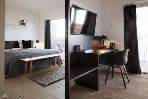 a bedroom with a bed and a desk with a chair at CPH Studio Hotel in Copenhagen