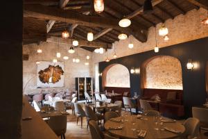 a restaurant with tables and chairs and chandeliers at La Sauternaise, luxury Boutique B&B in Sauternes