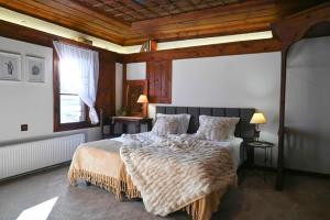a bedroom with a large bed and a wooden ceiling at Конак Буката in Bukata