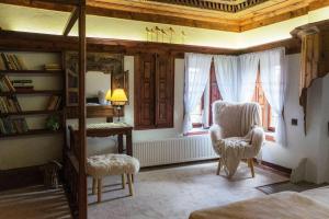 a bedroom with a bed and a chair and a mirror at Конак Буката in Bukata