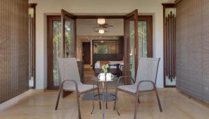 a dining room with a glass table and chairs at Trance Sunderban Resort in Pune