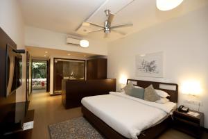 a bedroom with a bed and a ceiling fan at Trance Sunderban Resort in Pune