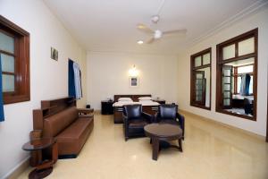 a living room with a couch and a table and chairs at Trance Sunderban Resort in Pune