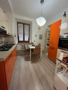 a kitchen with orange cabinets and a table with chairs at Vicolo in Fiore House in Orvieto