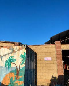a painting of palm trees on the side of a building at Дом у Озера in Priozersk +2 photos