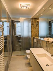 a bathroom with a shower and a toilet and a sink at Nashira Apartments in Lignano Sabbiadoro +100 photos