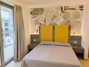 a bedroom with a bed and a large window at Nashira Apartments in Lignano Sabbiadoro