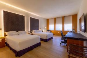 a hotel room with two beds and a desk at Barceló Monterrey Valle in Monterrey +34 photos