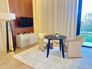 a living room with a table and chairs and a television at Seabreeze Baku White Residence Studio, Terrace in Baku