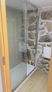 a shower in a bathroom with a stone wall at Casa dos Devezas in São Gregório +10 photos