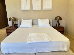 a large bed with white sheets and pillows at Seabreeze Baku White Residence Studio, Terrace in Baku +15 photos