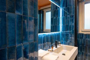 a blue tiled bathroom with a sink and a mirror at Marcello's Como Lake in Como +25 photos