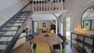 a dining room with a wooden table and a staircase at La Santoline - Provençal break with pool in Le Thor