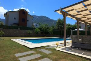 a swimming pool in a yard with a pergola at Cesur Villa 2 in Fethiye