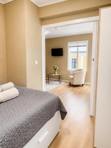 a bedroom with a bed and a chair and a television at Barfot Apartment - Bergen City center in Bergen