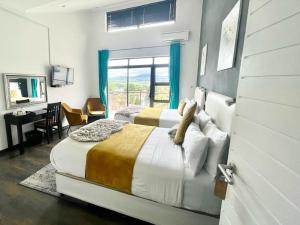 a bedroom with two beds and a desk and a window at Scenery Guest House in Kokstad